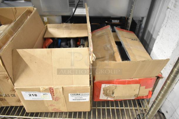 Auction boxes containing 180 sharpened stainless steel knives, including chef, filet, and poultry knives. Box labeled "Cozzini."