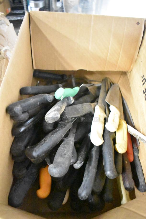 Box of 120 sharpened stainless steel knives, including filet knives, with black, green, and yellow handles. Auction item.