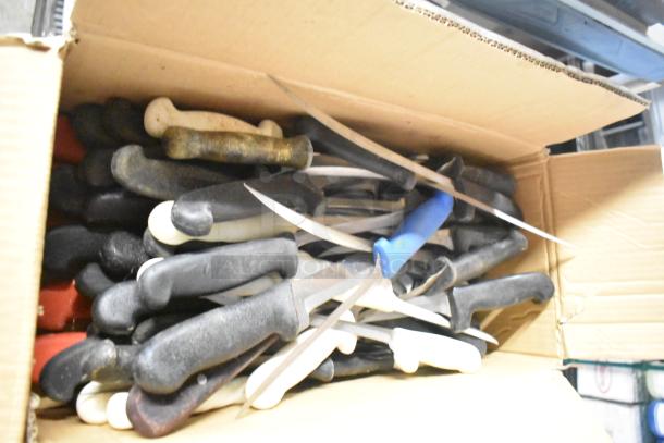 Box of assorted stainless steel knives, including filet, serrated, and rocking cutter, various handles, used condition.