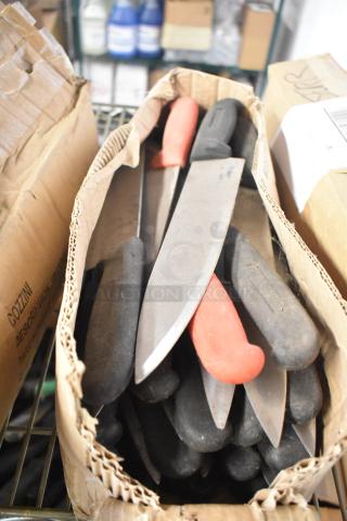 Box of 180 sharpened stainless steel knives, including chef and serrated knives, housed in cardboard, some with red handles.