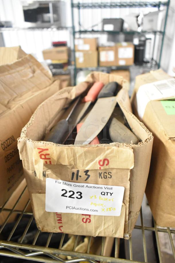 Box of 180 sharpened stainless steel knives, including chef and serrated knives. Label indicates weight and quantity.
