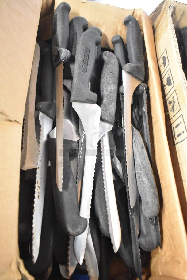 Box of 180 sharpened stainless steel knives, including chef and serrated varieties, with black handles.