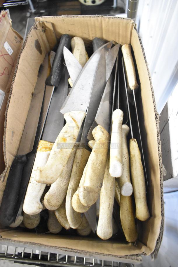 Box of 180 sharpened stainless steel knives including chef and serrated knives. Mixed condition handles, ideal for bulk purchase.