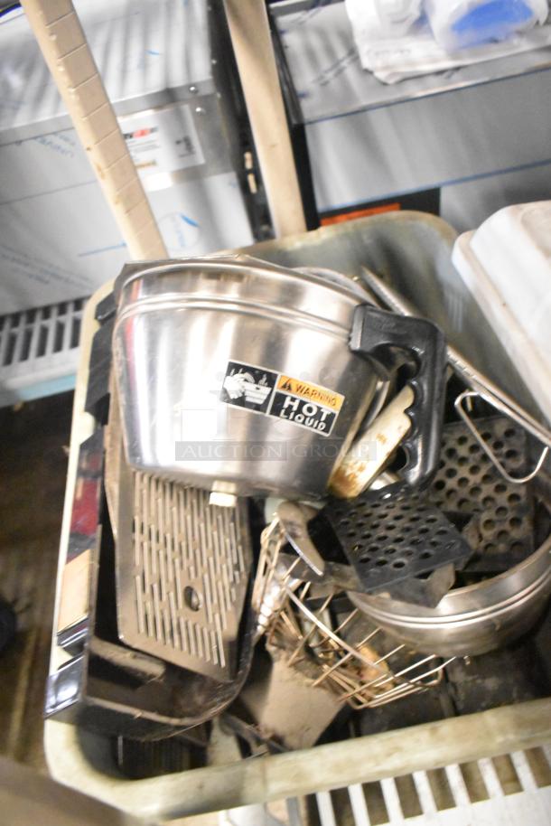 Tiered lot of miscellaneous kitchen items, including brew baskets and drip trays, featuring a metal container with a "Hot Liquid" warning label.