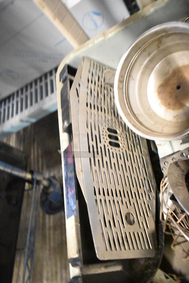 Auction lot featuring assorted brew baskets and drip trays in used condition. Stacks show minor wear.