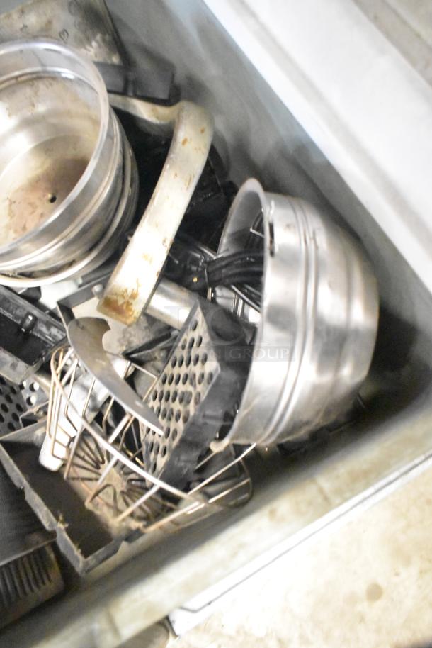 Tier lot of assorted metal items, including brew baskets and drip trays, in used condition. Variety of shapes and sizes.