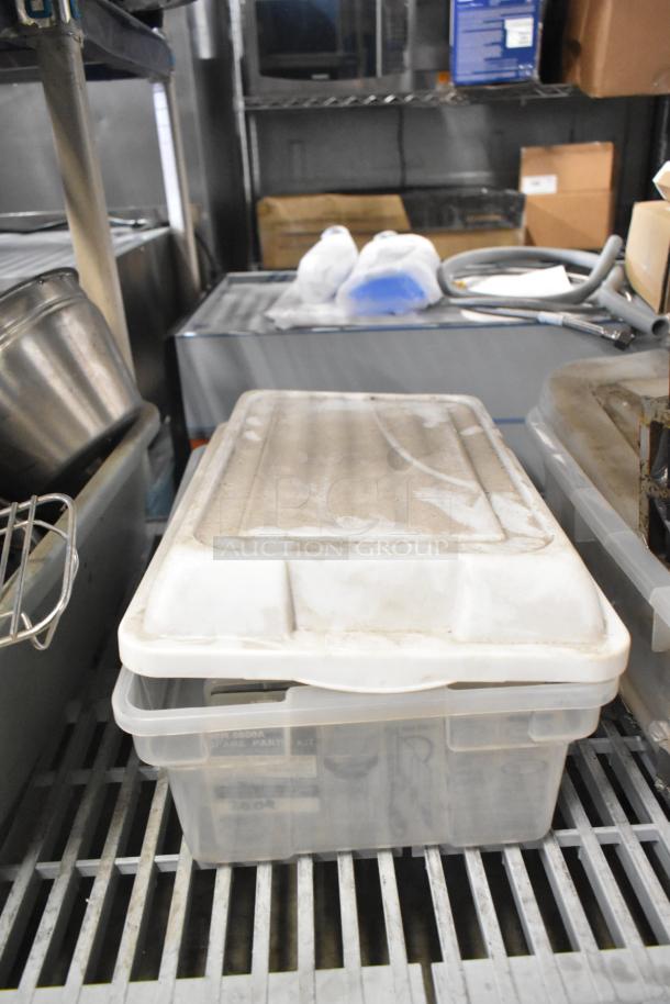 Plastic bin on metal shelf, containing various items including brew baskets and drip trays, partially visible in storage.