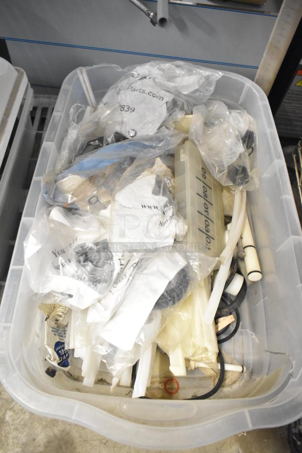 Plastic bin containing assorted items including brew baskets and drip trays, some in original packaging. Various shapes and materials.