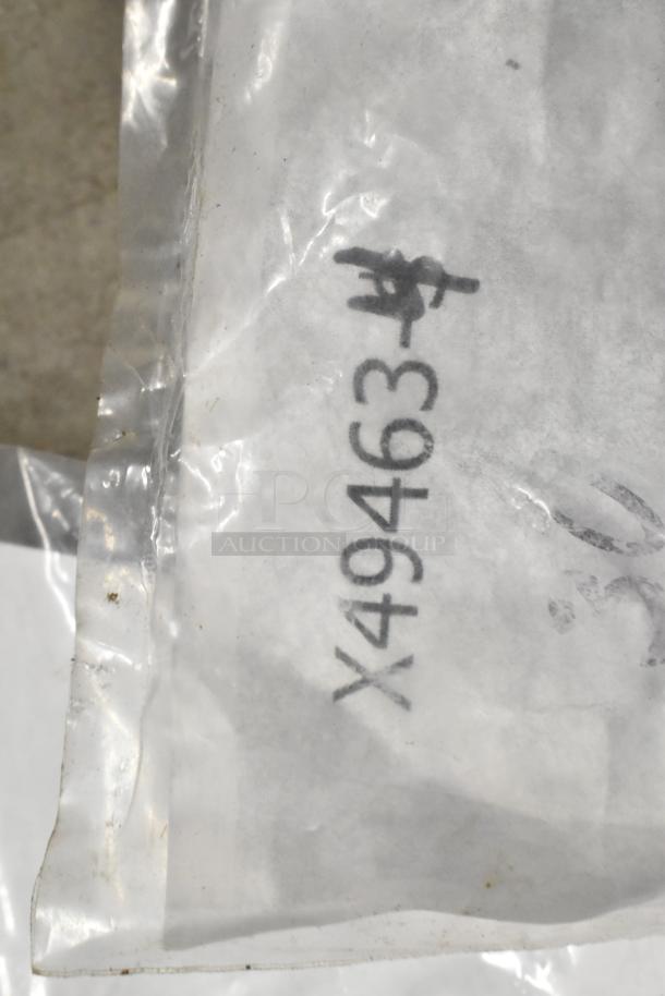 Plastic bag with printed code "X49463" containing various items including brew baskets and drip trays.
