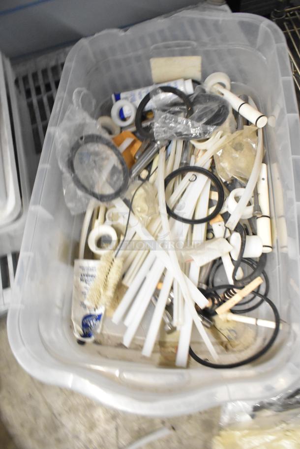 Plastic bin with assorted items, including brew baskets, drip trays, and tubing. Various sizes, used condition.