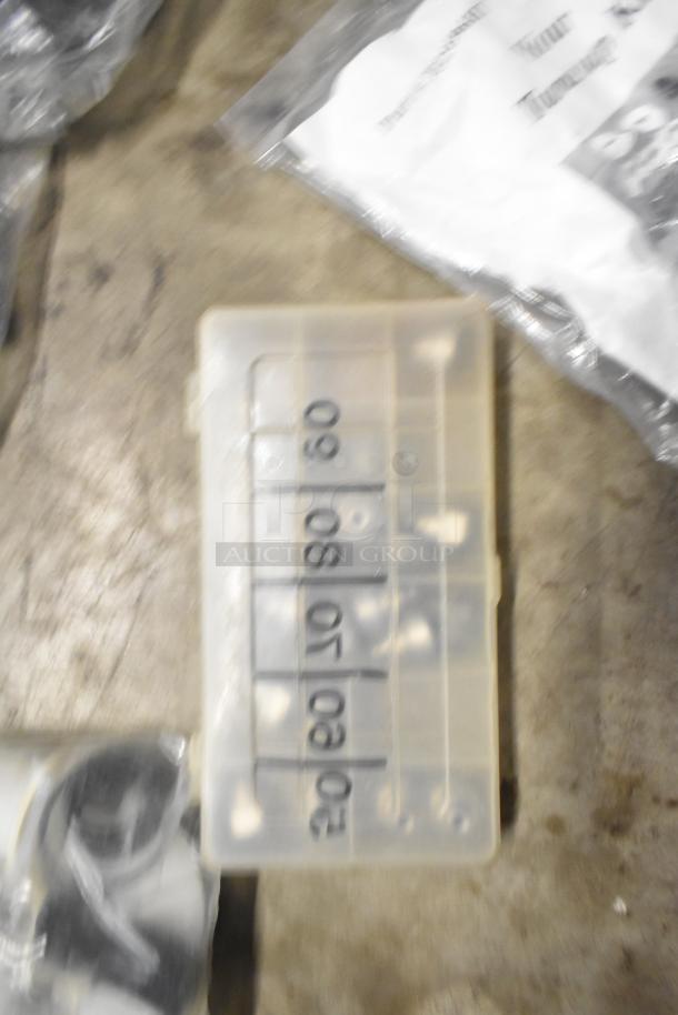 Assorted items including brew baskets and drip trays in mixed condition; plastic container labeled "60/50/40/30/20/10."