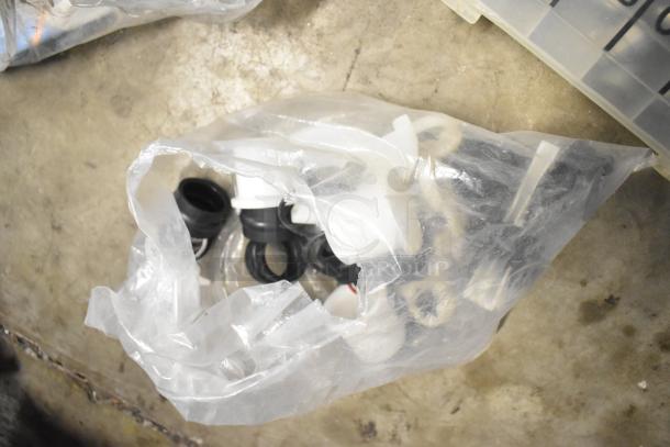 Bag of assorted brew baskets and drip trays in varying condition on concrete floor. Items appear unused and are partially visible.