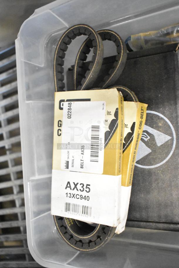 Clear plastic bin containing belts, including Carlisle AX35 cog belt with barcode and serial label.