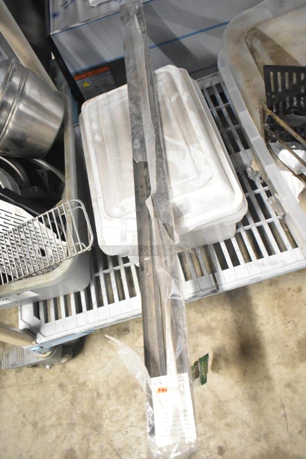 Assorted kitchen items including brew baskets and drip trays in used condition, with items stacked on shelves.