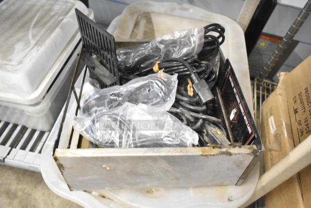 Tier lot with various items including brew baskets and drip trays. The condition indicates signs of wear. Some parts are in plastic bags. Visible label reads: "Caution: Hot Liquid. Handle with Care."