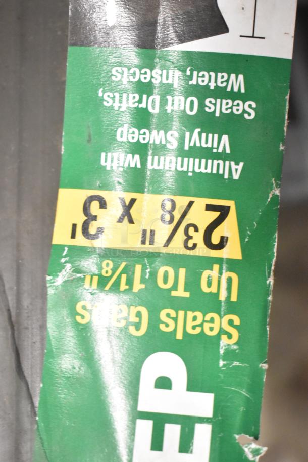 Auction lot sign showing size specs: 2 3/8" x 3 3/8", aluminum with vinyl sweep, seals gaps up to 1 7/8".