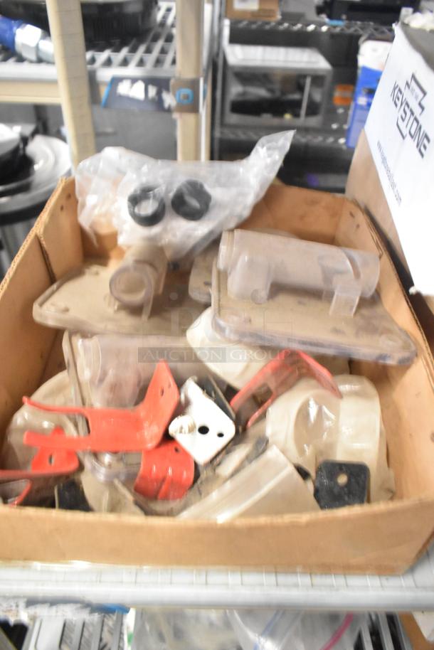 Cardboard box containing various industrial parts, including Flavor Burst parts, bin liners, and TurboChef kickplate, in mixed condition.