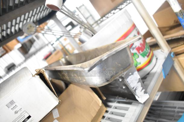 Auction lot with various items including Flavor Burst parts, drop-in bin, Turbochef kickplate. Additional boxes and containers visible.