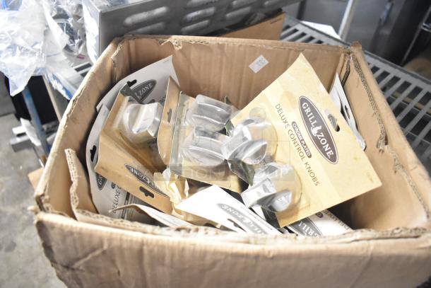 Cardboard box of mixed items including Grill Zone deluxe control knobs, Flavor Burst parts, and Turbochef kickplate.