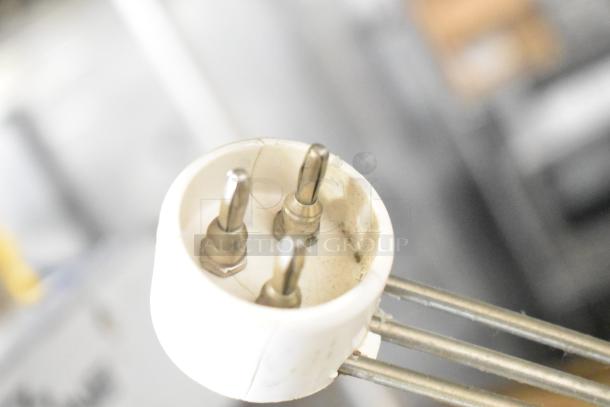 Assorted hardware components including a plug adapter with three metal prongs, showing signs of wear.