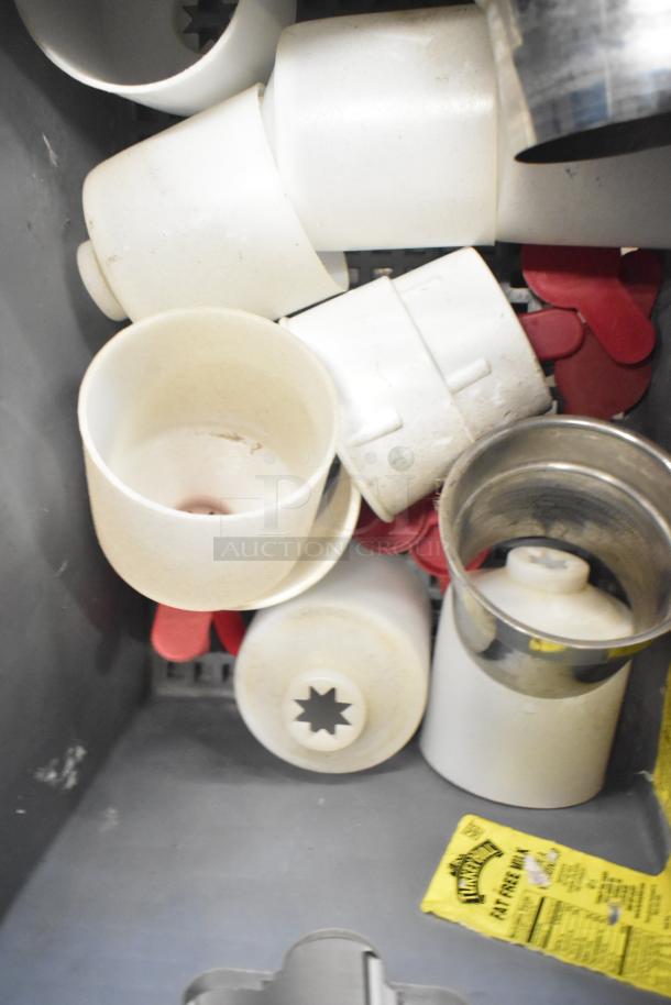 A collection of various plastic mixing cup collars and fluorescent sockets in fair condition, with some visible wear.