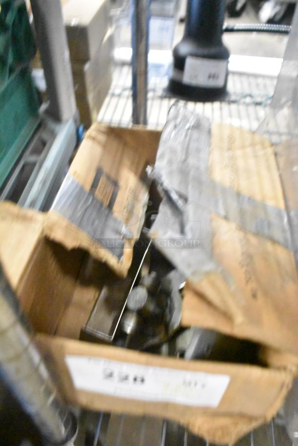 Box with various industrial items, including range grates, slushie machine hopper, and Turbochef kickplates, visible label.