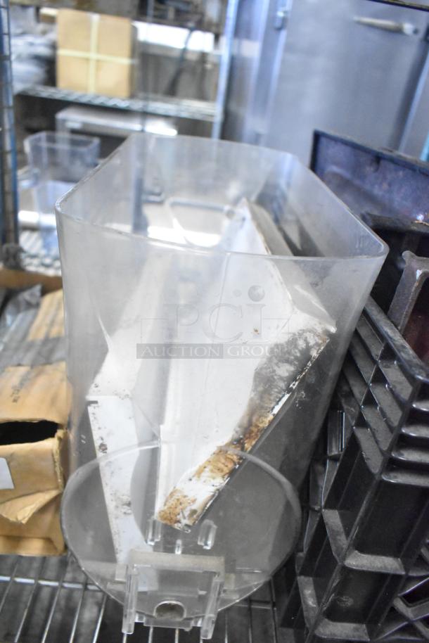 Range grates, slushie machine hopper, and Turbochef kickplates in mixed condition on metal shelf.