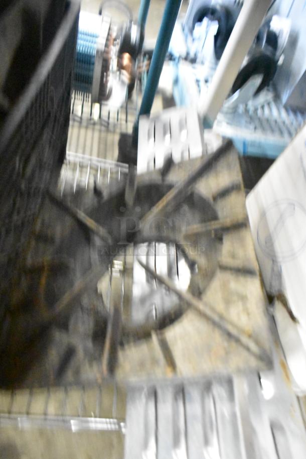 Blurred image of assorted kitchen items including range grates, a slushie machine hopper, and Turbochef kickplates on a wire rack.