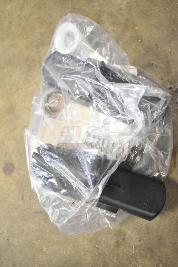 A lot of assorted items in clear plastic, including metal parts, plastic components, and grating blade, all in used condition.