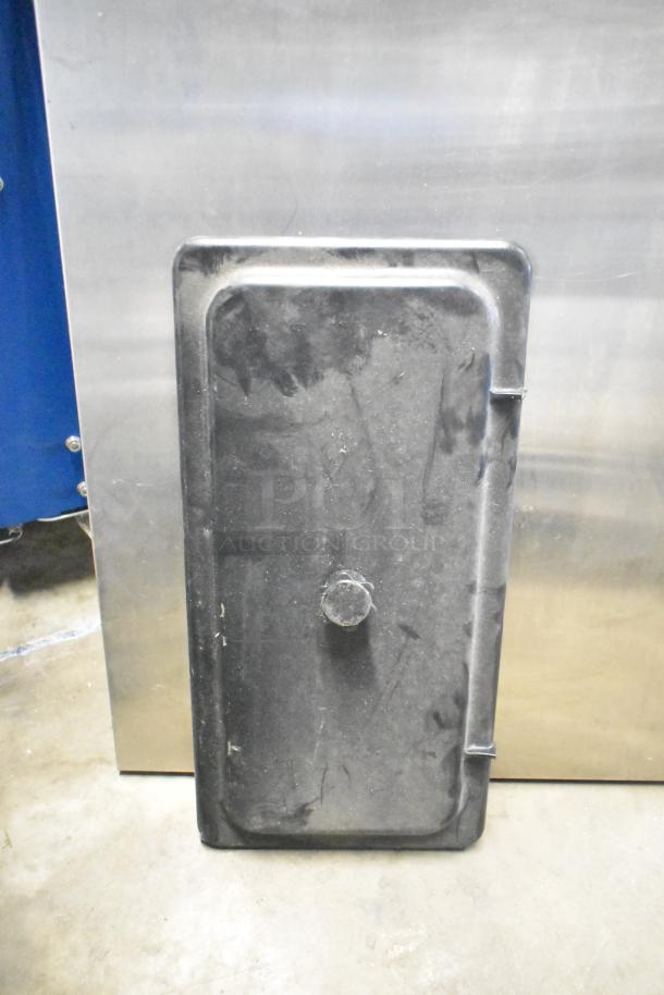 Black rectangular metal panel with a central knob, used and slightly worn, part of a mixed auction lot.