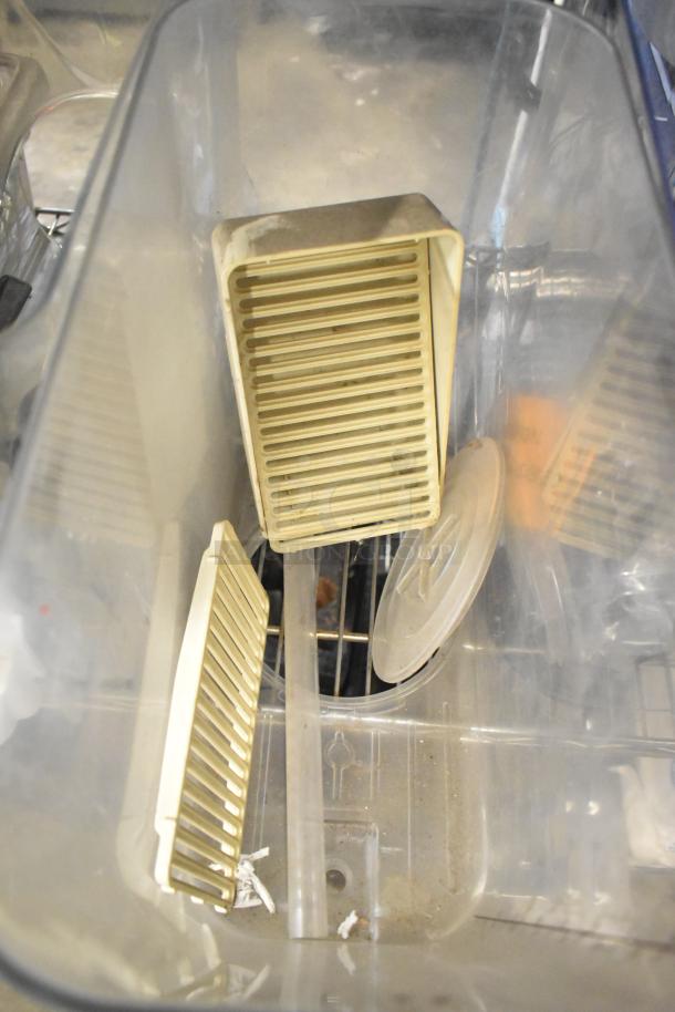 Tier lot including slushie machine hoppers, metal panels, meat grinder tray, and Pelican head grating blade shown in a container.