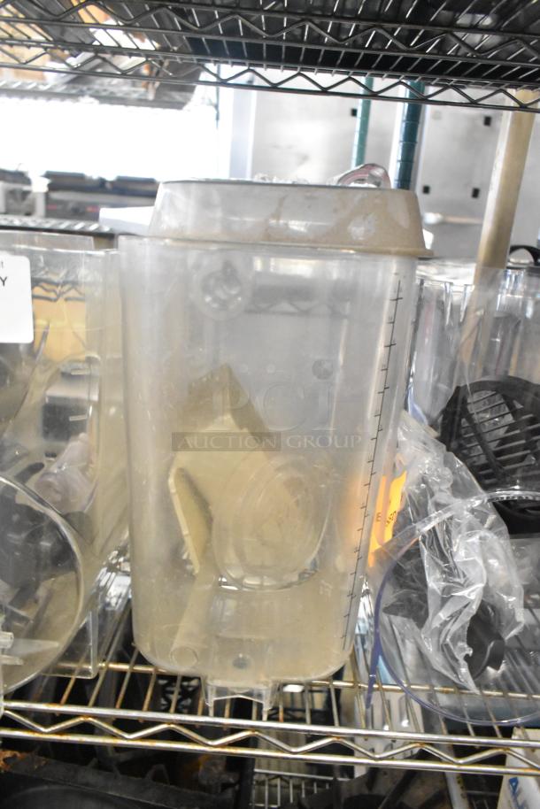 Auction lot with slushie machine hoppers, metal panels, meat grinder tray, and a Pelican head grating blade on a shelf.