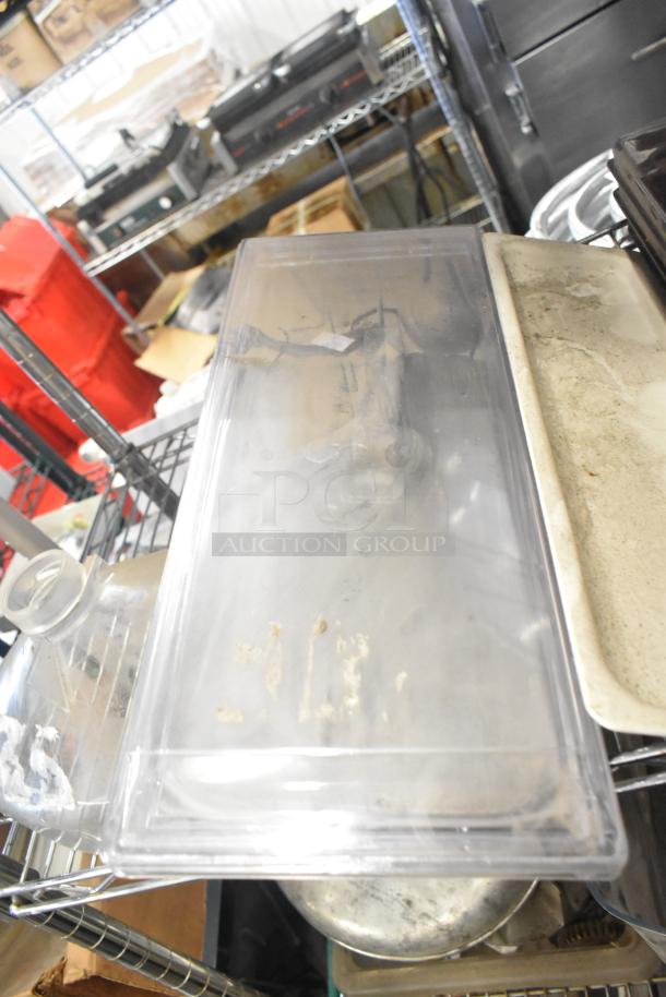 Auction lot of various items including ice cream machine lids, filter drier, portafilters, Bunn dispenser spouts, and more.