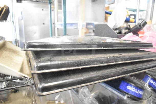 Tiered lot of various commercial kitchen items including black ice cream machine lids stacked on shelving.