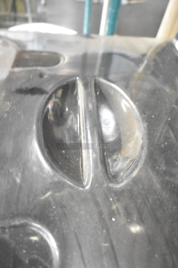 Plastic ice cream machine lid with a glossy black finish, showing minor scuffs and scratches.