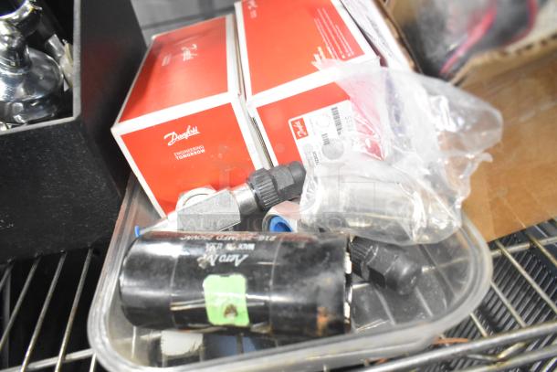 Various items including Danfoss filter driers, ice cream machine lids, switch kit, portafilters, and Bunn dispenser spouts.