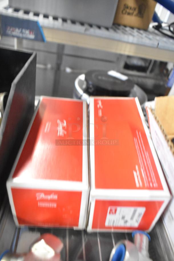 Various items on a shelf including red Danfoss 023Z5029 boxes, indicating Eliminator Hermetic Filter Driers.