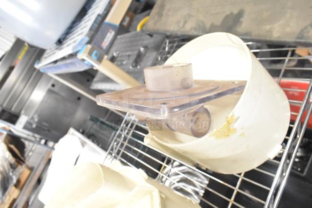 Tier lot of kitchen equipment on metal shelf including Pelican head blade, grating/slicing blades, and meat slicer carriage.