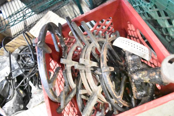 Red crate containing assorted range burners, grates, and wires. Items show signs of rust. Mixed condition hardware lot.