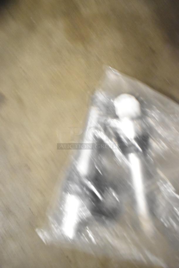 Blurry image of a plastic bag containing Taylor ice cream machine parts and carbonated beverage machine adapters.