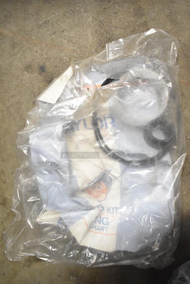 Clear plastic bag containing assorted Taylor ice cream machine parts and carbonated beverage machine adapters. Appears used.