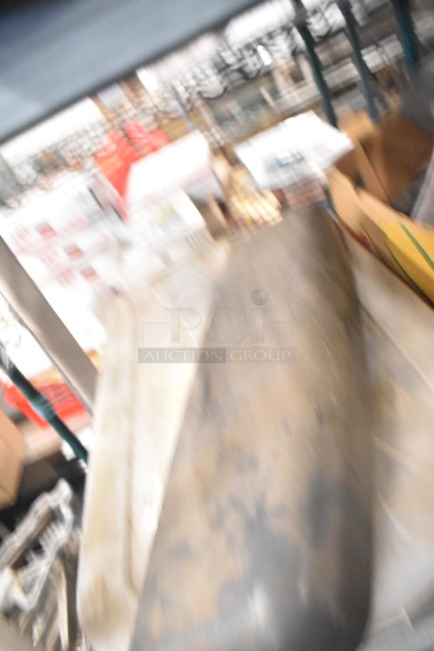 Blurry image of assorted items including Taylor ice cream machine parts and carbonated beverage machine adapters in a warehouse.