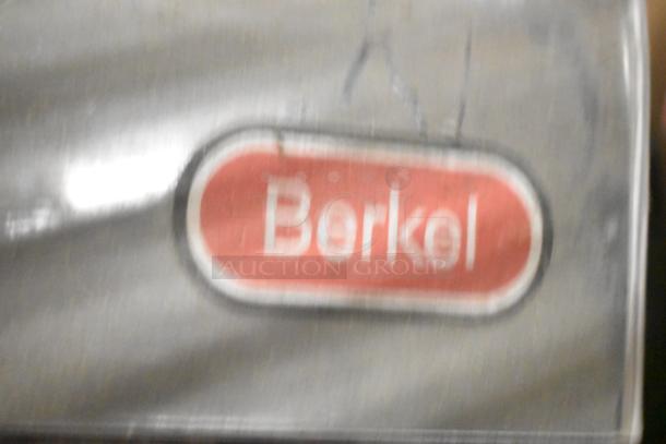 Label showing "Berkel" on a silver surface, part of a tier lot with Taylor ice cream machine parts and beverage adapters.