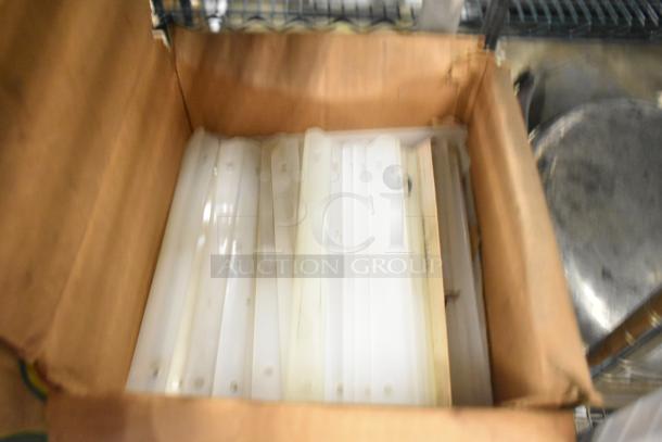 Box containing various Taylor ice cream machine parts, possibly including carbonated beverage machine adapters, in fair condition.