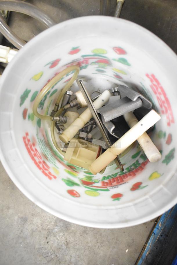 Bucket containing various machine parts: Turbochef kickplate, Taylor ice cream machine drip tray, carbonated beverage machine drip tray.