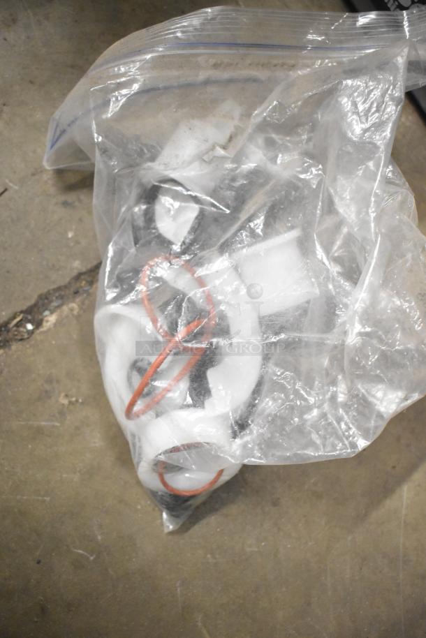 Bag of various plastic fittings and rubber gaskets, part of a tiered auction lot. Items appear in used condition.