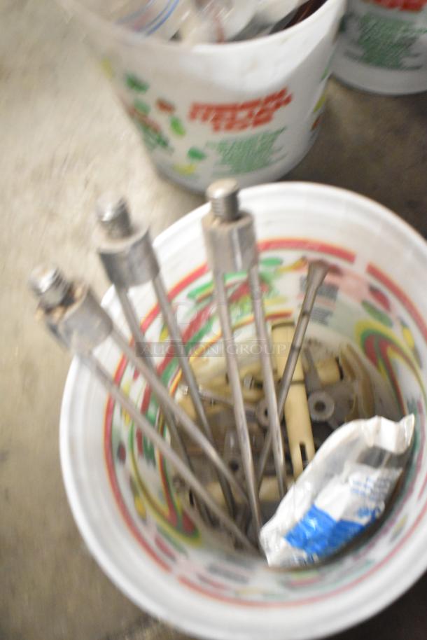 Bucket containing metal rods and miscellaneous parts, including a turbochef kickplate and ice cream machine drip tray.
