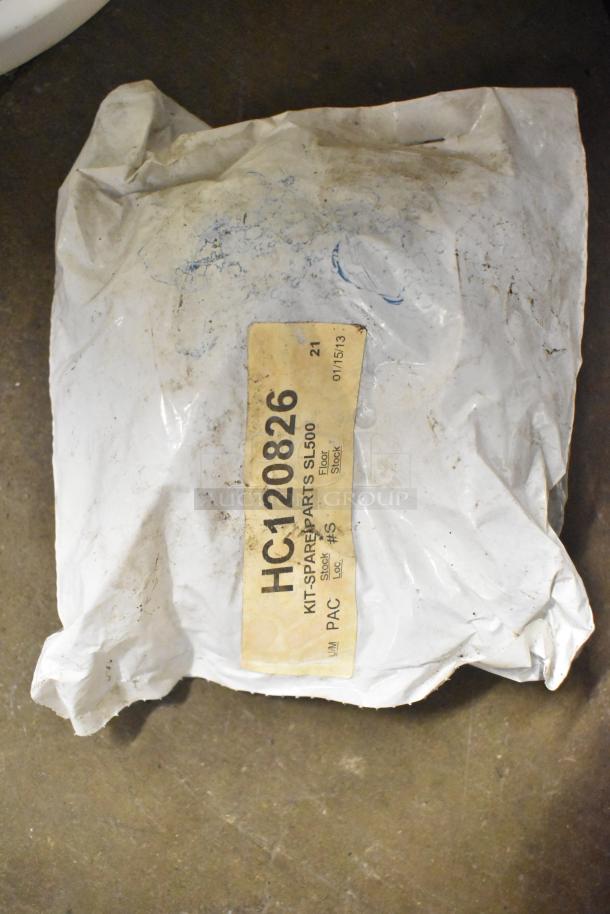 Dusty package labeled HC120826, "Kit Spare Parts SL500," on a concrete floor, condition appears used.