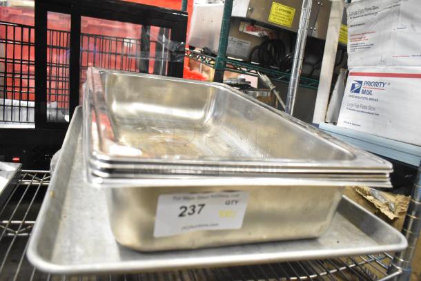 Stainless steel drop-in bins stacked on a metal baking pan; visible label reads "237" indicating lot number.