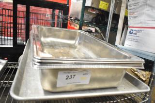 Stainless steel drop-in bins stacked on a metal baking pan; visible label reads "237" indicating lot number.